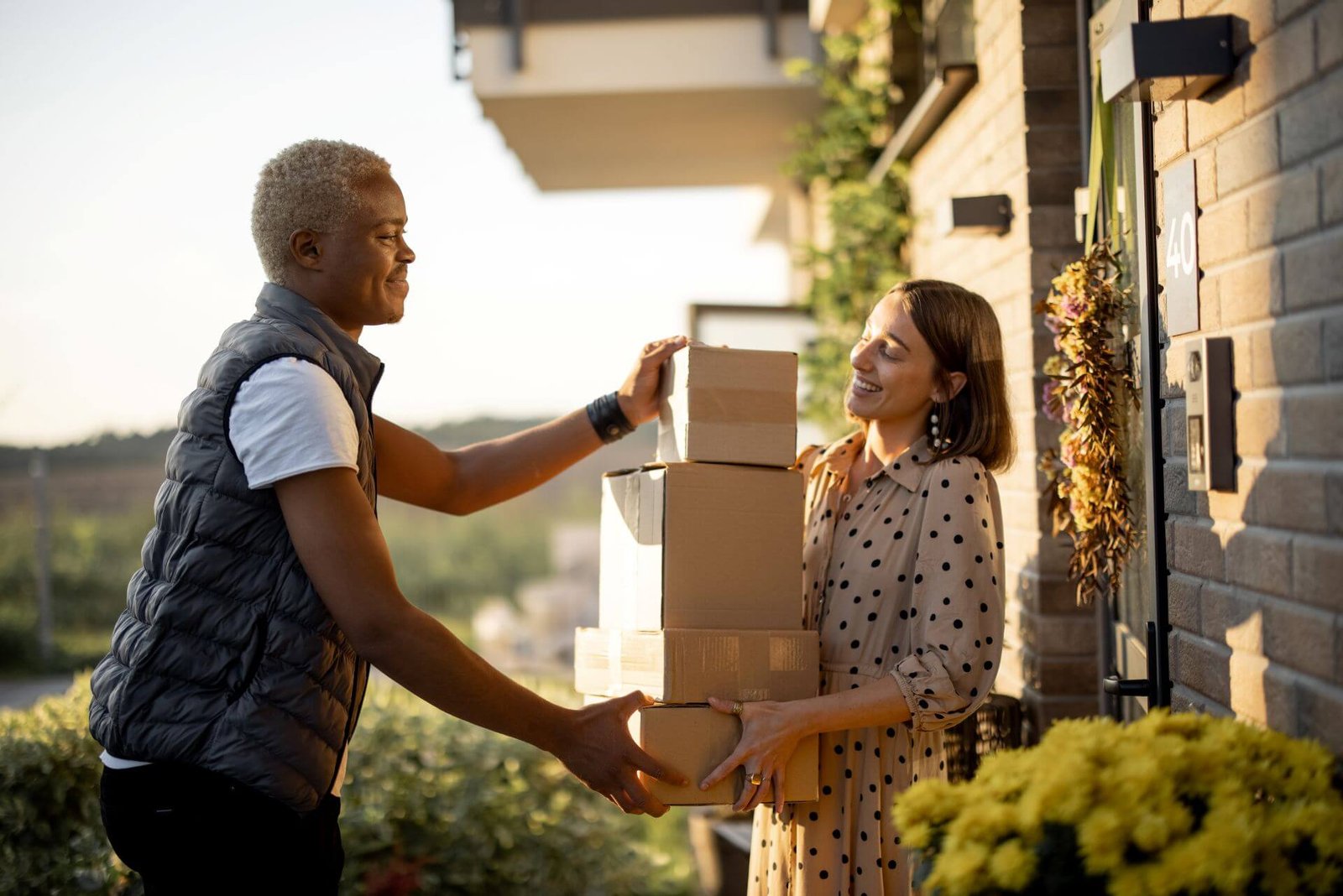 delivery-man-giving-parcels-to-caucasian-woman-2023-11-27-05-33-26-utc.jpg